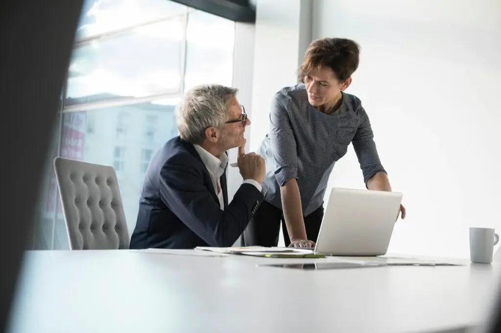 Businessman and businesswoman with laptop in office